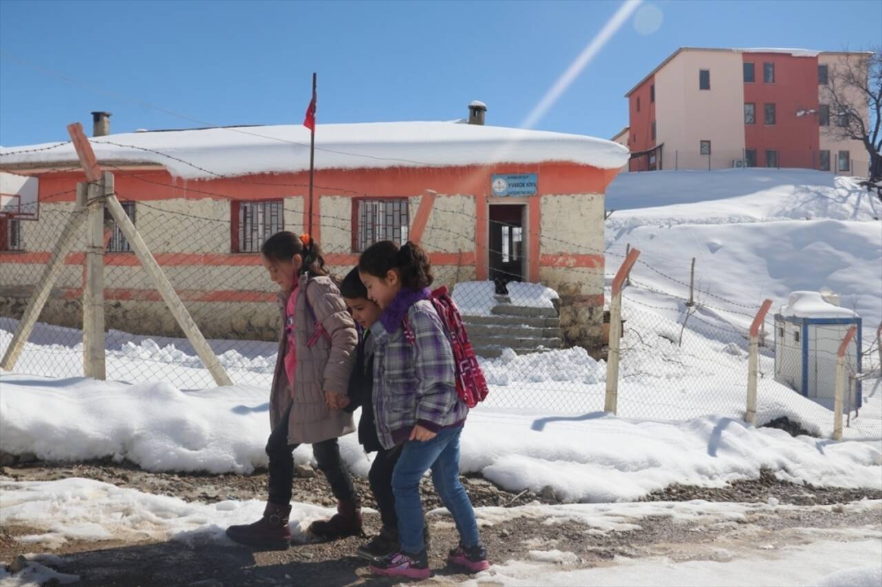 Sobayı yakıp okul yolunu kardan temizleyerek öğrencilerini karşılıyor