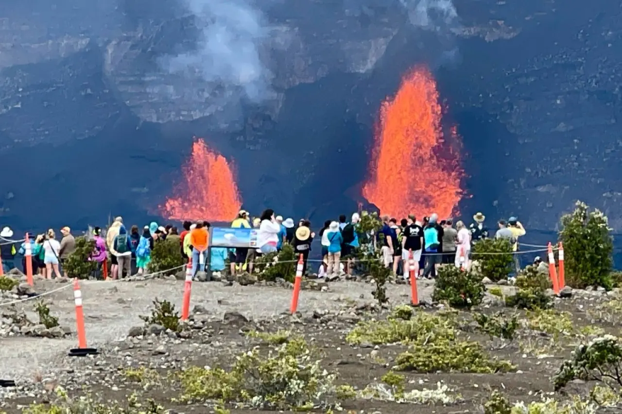 Lava fountains erupting from Kilauea volcano in Hawaii with a group of people observing