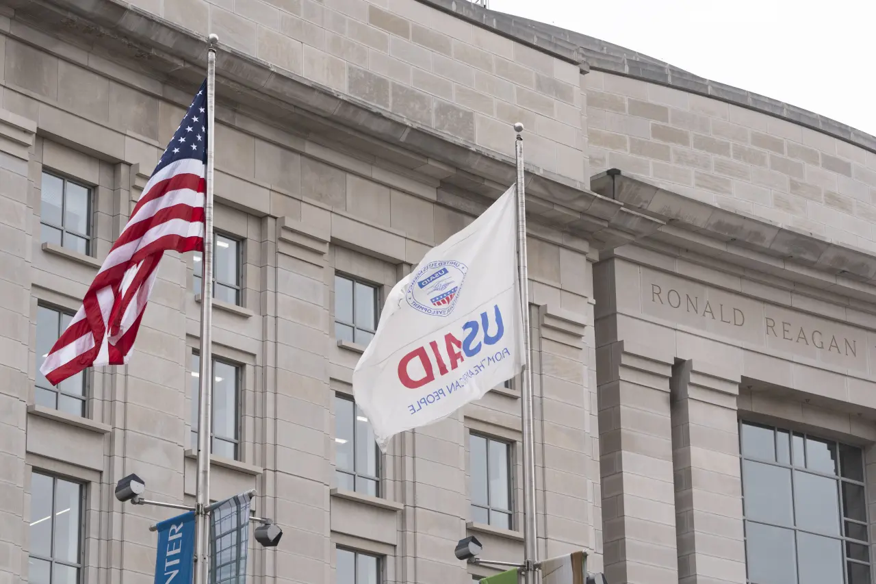 The flag of the United States Agency for International Development, or USAID, right, flies alongside the American flag in front the USAID office in Washington, Monday, Feb. 3, 2025. (AP Photo/Manuel Balce Ceneta)